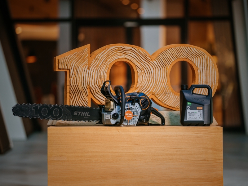 MotoMix 100 with a chainsaw and 100 Years wood sculpture