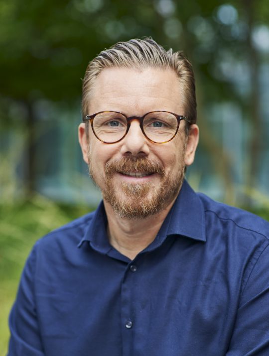 Portrait photo of a man wearing glasses.