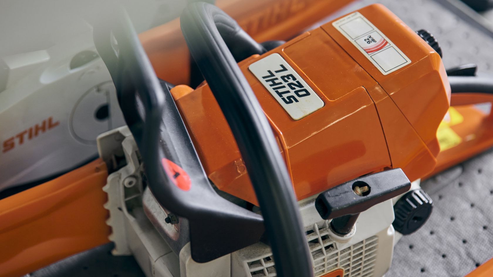 Stylized illustration of the STIHL 023 L chainsaw.