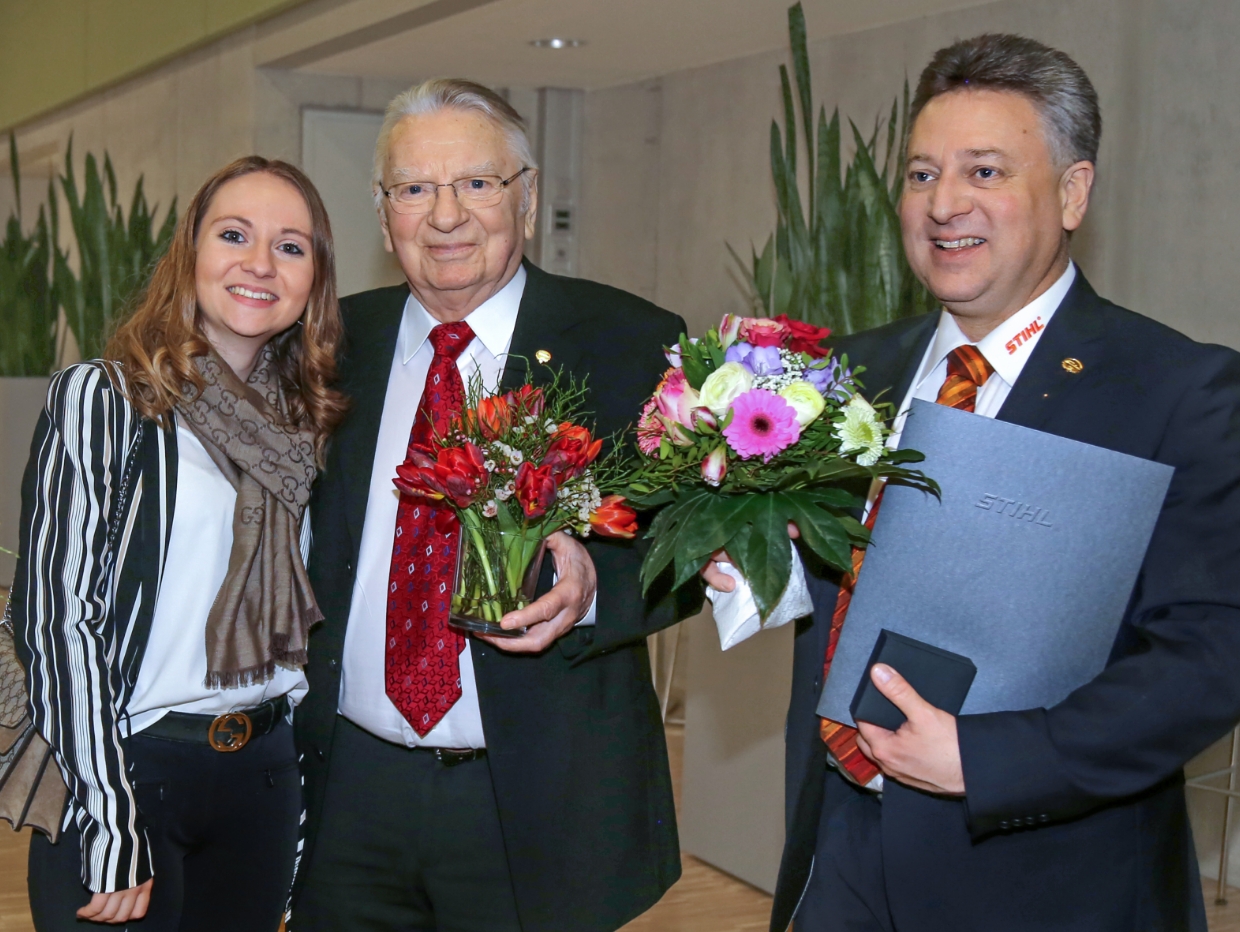 Group photo with certificate and flowers.