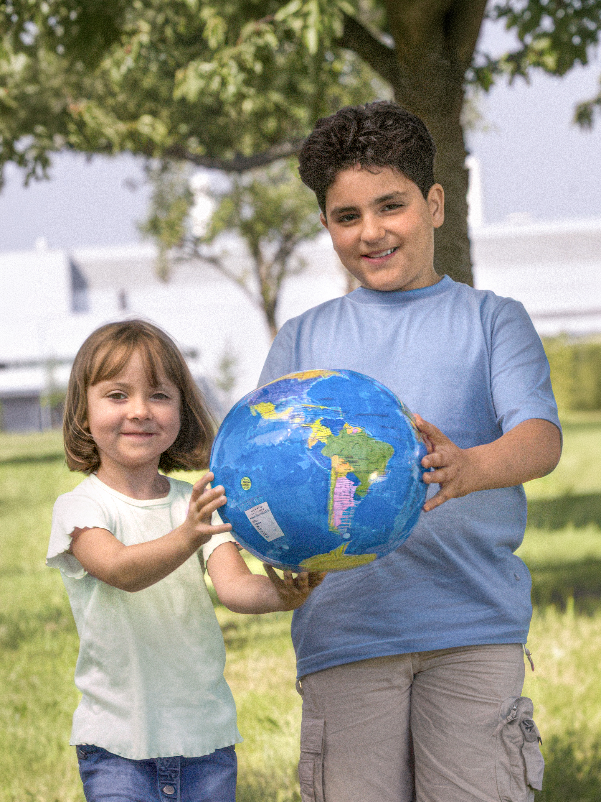 A girl and a boy are holding a globe.