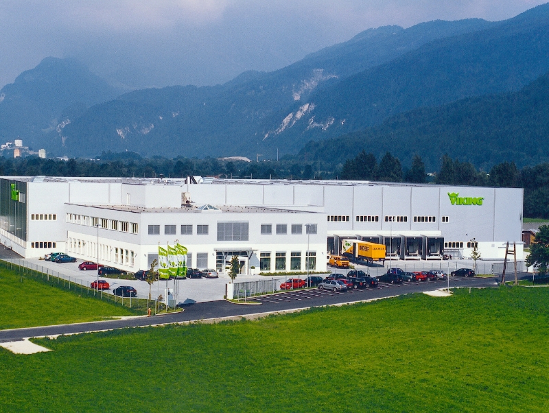 Company building in front of a mountain backdrop.