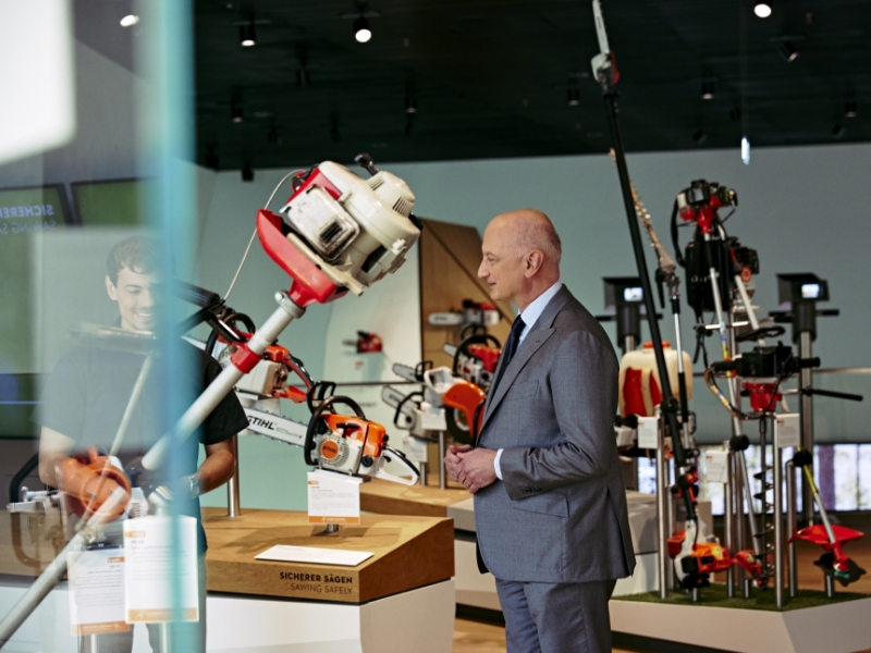 Dr. Nikolas Stihl and Tamino Soubawi talk surrounded by chainsaws and other STIHL tools on display.