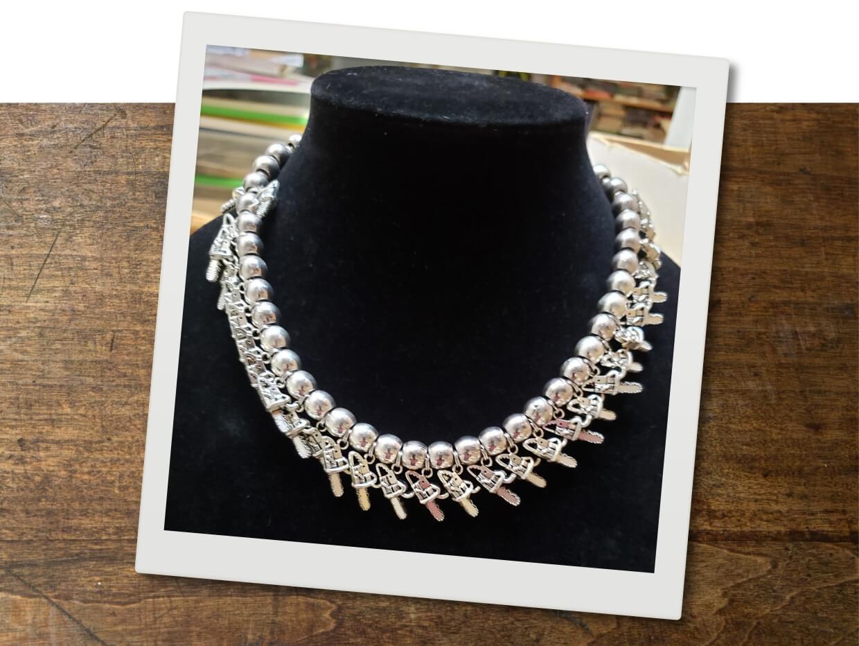 A necklace with chainsaw pendants on a display mannequin.