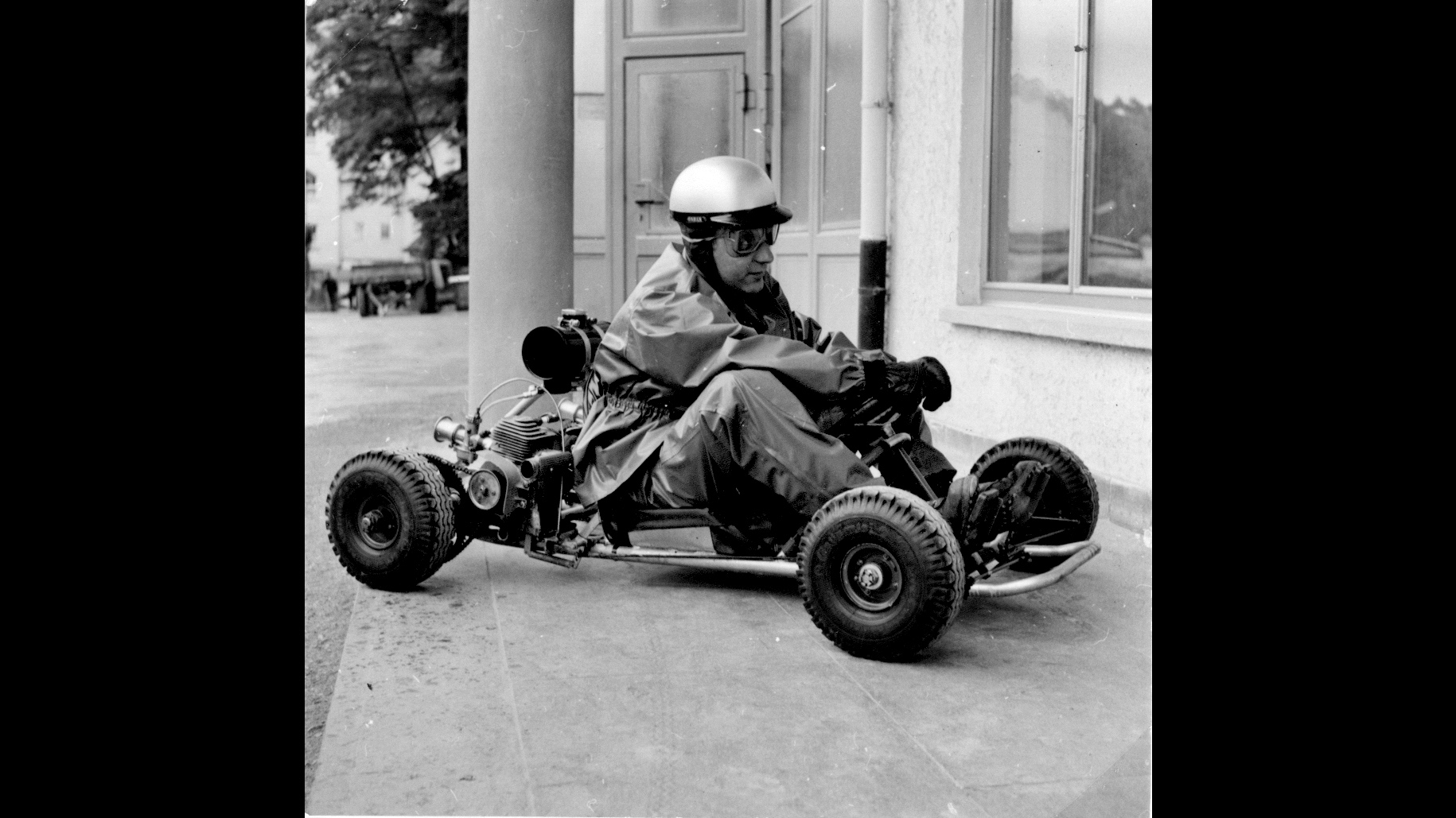 A go-kart with driver; black-and-white photo.