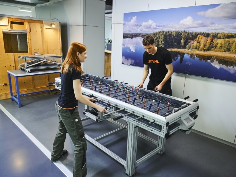A young woman and a young man play a game of foosball.