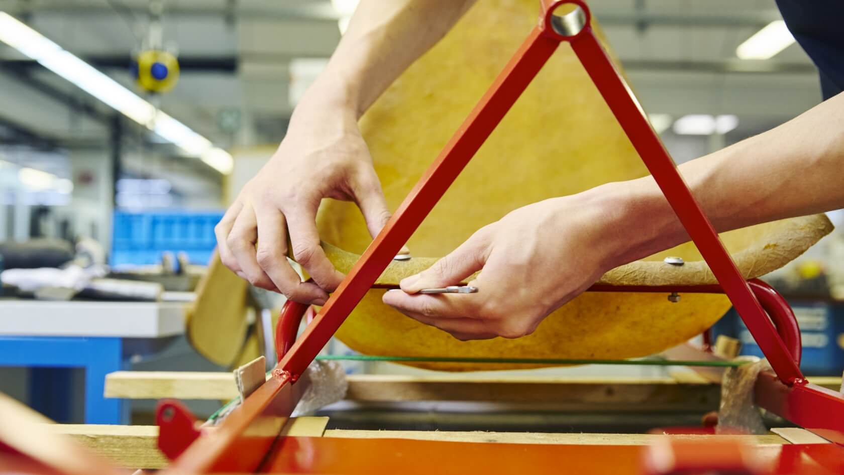 A close-up of two hands tightening a bolt on a go-kart.